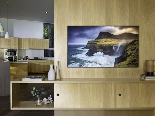 Samsung QN65Q70R hanging on wood finish wall in stylish living room setting
