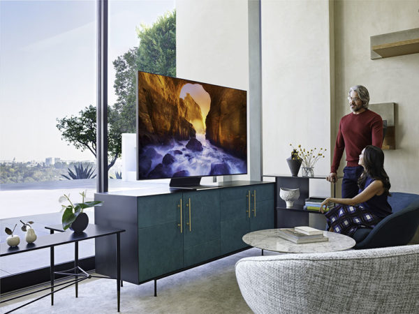 Couple in stylish living room admiring Samsung Q90 series TV